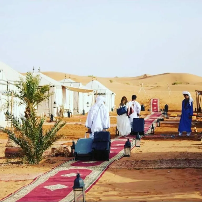 Travelers arriving at a desert camp with their luggage on 3 Day Desert Tour from Errachidia