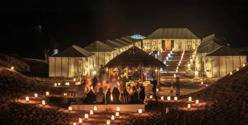 Desert camp in the Erg Chebbi dunes lit by lanterns at night