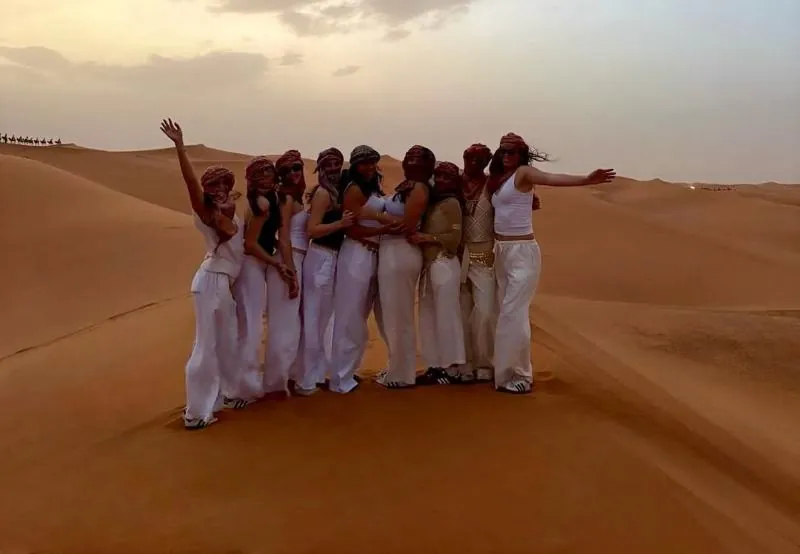 Student group celebrating in the Sahara desert on 4 Days Tangier to Marrakech Desert Tour