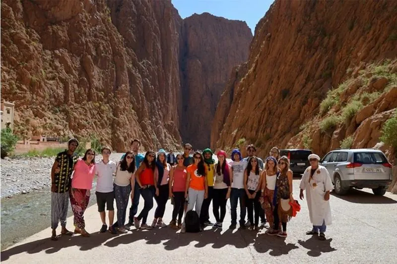 Travelers walking through the towering Todra Gorge on 3 Day Errachidia to Marrakech Desert Tour